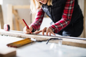 Young woman worker in the carpenter workroom.